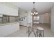 Bright kitchen with tile floors, white cabinets, an eat-in bar and stainless steel appliances at 10802 W Cameo Dr, Sun City, AZ 85351