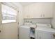 Practical laundry room with washer, dryer, and overhead cabinets for storage at 10802 W Cameo Dr, Sun City, AZ 85351