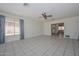 Comfortable living room with neutral tile floors, ceiling fan, and seamless flow into dining area at 10802 W Cameo Dr, Sun City, AZ 85351