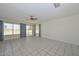 Bright living room with tile floors, ceiling fan, and large windows offering outdoor views at 10802 W Cameo Dr, Sun City, AZ 85351