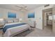 Comfortable main bedroom with blue accents, plush carpet, and an en-suite bathroom at 10802 W Cameo Dr, Sun City, AZ 85351