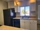 Well-lit kitchen featuring white cabinets, granite countertops, and black appliances at 3500 N Hayden Rd # 402, Scottsdale, AZ 85251