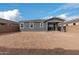 Large backyard with dirt ground and a gray house in the background at 40519 W Wade Dr, Maricopa, AZ 85138