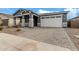 Single-story home with gray exterior, stone accents, and a two-car garage at 40519 W Wade Dr, Maricopa, AZ 85138