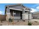 Single-story home with gray exterior, stone accents, and a two-car garage at 40519 W Wade Dr, Maricopa, AZ 85138