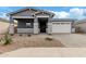 Single-story home with gray exterior, stone accents, and a two-car garage at 40519 W Wade Dr, Maricopa, AZ 85138