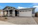 Single-story home with gray exterior, stone accents, and a two-car garage at 40519 W Wade Dr, Maricopa, AZ 85138