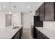 Modern kitchen island with white countertop and dark cabinets at 40519 W Wade Dr, Maricopa, AZ 85138