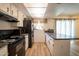 Kitchen features white cabinets, black appliances, wood floors and countertop bar with granite countertop at 6337 N 49Th Ave, Glendale, AZ 85301