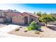 Attractive single-story home featuring a desert landscape, two-car garage, and a red tile roof under a bright blue sky at 10649 W Monte Vista Rd, Avondale, AZ 85392