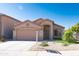 Welcoming home with a well-maintained front yard, two-car garage, and a charming facade under a clear blue sky at 10649 W Monte Vista Rd, Avondale, AZ 85392