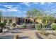 Home's exterior features desert landscaping and a welcoming entrance with curtains at 8167 E Sand Flower Dr, Scottsdale, AZ 85266