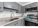 Kitchen featuring stainless steel appliances, quartz countertops and gray cabinets at 2610 W Berridge Ln # C115, Phoenix, AZ 85017