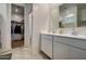 Bright bathroom with double vanity sinks, a mirror, and a view to the walk-in shower and closet at 1157 W Paradise Way, Casa Grande, AZ 85122