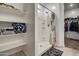 Bathroom featuring a walk-in shower, shelving, and a glimpse into the walk-in closet at 1157 W Paradise Way, Casa Grande, AZ 85122