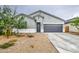 Charming single-story home featuring a two-car garage, desert landscaping, and modern architectural details at 1157 W Paradise Way, Casa Grande, AZ 85122