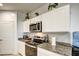 A kitchen is set up with a stainless steel microwave and a black stovetop at 1157 W Paradise Way, Casa Grande, AZ 85122