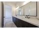 Bathroom featuring a double sink vanity with a large mirror, modern fixtures, and elegant countertops at 1101 E Dolores Rd, Phoenix, AZ 85086