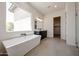 Bright bathroom with a modern tub, vanity, and natural light streaming through the large window at 1101 E Dolores Rd, Phoenix, AZ 85086