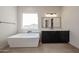 Modern bathroom with a stand-alone tub, dark vanity and large window at 1101 E Dolores Rd, Phoenix, AZ 85086