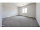 A well-lit bedroom with neutral walls and carpet, and a window providing natural light throughout the room at 1101 E Dolores Rd, Phoenix, AZ 85086