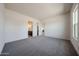 Spacious bedroom featuring neutral carpet, a window for natural light, and doorways to the ensuite and closet at 1101 E Dolores Rd, Phoenix, AZ 85086