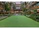 Lush condo courtyard featuring a putting green surrounded by vibrant greenery, palm trees, and water features at 7127 E Rancho Vista Dr # 4012, Scottsdale, AZ 85251