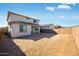 View of the backyard featuring privacy wall, large dirt area ready for landscaping, and partial covered patio at 17632 W Oregon Ave, Litchfield Park, AZ 85340