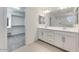 Bright bathroom featuring double vanity sink with modern cabinetry and an adjacent walk-in closet at 17632 W Oregon Ave, Litchfield Park, AZ 85340