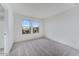 Well-lit bedroom with plush carpet, two windows, and an attached bathroom at 17632 W Oregon Ave, Litchfield Park, AZ 85340