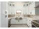 White kitchen with farmhouse sink and stainless steel appliances at 7917 E Bonnie Rose Ave, Scottsdale, AZ 85250