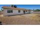 The back exterior of the home has desert landscaping, large windows and a sliding glass door at 3222 W Wagoner Rd, Phoenix, AZ 85053