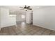 Spacious living room featuring tile flooring, a ceiling fan, and neutral paint colors, creating a bright and airy space at 3222 W Wagoner Rd, Phoenix, AZ 85053