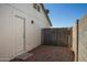 A side view of the home shows a door, gate and a small area with desert landscaping at 3222 W Wagoner Rd, Phoenix, AZ 85053