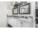 Luxurious bathroom vanity with double sinks, marble countertop, and modern black-framed mirrors at 4020 W Anderson Dr, Glendale, AZ 85308