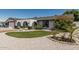 Charming home with white rock landscaping, green grass, and decorative desert flora at 4020 W Anderson Dr, Glendale, AZ 85308