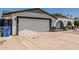 Exterior view of a home featuring a two-car garage and arched front entryway at 4020 W Anderson Dr, Glendale, AZ 85308