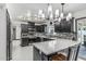 Modern kitchen featuring dark cabinets, stainless steel appliances, island with marble countertop and backsplash detail at 4020 W Anderson Dr, Glendale, AZ 85308
