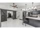 Open-concept living room with white tiled flooring, dark wood accents, and barn door feature at 4020 W Anderson Dr, Glendale, AZ 85308