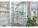 Modern shower with sleek marble tiles, glass enclosure, and decorative mosaic details at 4020 W Anderson Dr, Glendale, AZ 85308