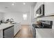 Bright kitchen featuring stainless steel appliances, white cabinets, and a breakfast bar at 5688 S 243Rd Dr, Buckeye, AZ 85326