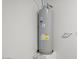 Water heater in a utility area against a white wall, featuring visible labels and connections at 5688 S 243Rd Dr, Buckeye, AZ 85326