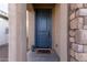 Modern front door with a stone accent wall and a welcome mat at 26935 W Zachary Dr, Buckeye, AZ 85396