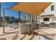 Barbecue area features bar seating and shade, overlooking the pool and community buildings at 2511 W Queen Creek Rd # 179, Chandler, AZ 85248