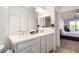 Well-lit bathroom features double sinks, sleek fixtures, and a glimpse into the luxurious bedroom at 2511 W Queen Creek Rd # 179, Chandler, AZ 85248