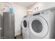 Efficient laundry room equipped with modern washer and dryer, plus a water heater at 2511 W Queen Creek Rd # 179, Chandler, AZ 85248