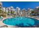 A large pool area surrounded by palm trees and multi-story apartment buildings on a sunny day at 2511 W Queen Creek Rd # 179, Chandler, AZ 85248