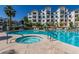 A large pool area surrounded by palm trees and multi-story apartment buildings on a sunny day at 2511 W Queen Creek Rd # 179, Chandler, AZ 85248