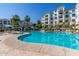 A large pool area surrounded by palm trees and multi-story apartment buildings on a sunny day at 2511 W Queen Creek Rd # 179, Chandler, AZ 85248