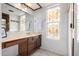 Clean bathroom with wood vanity, stained-glass window, and a large mirror at 18650 N 4Th St, Phoenix, AZ 85024